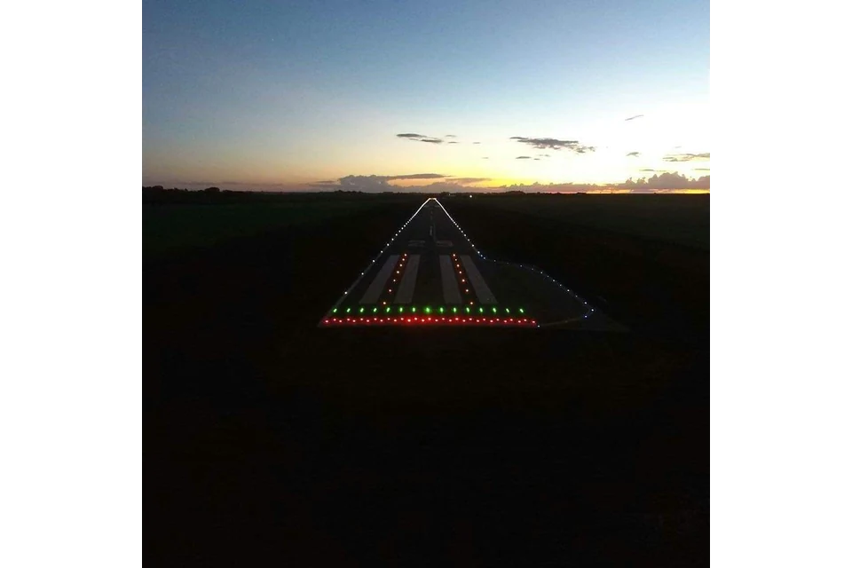 A second supplied dusk image of ground-level markers near an airfield-like area